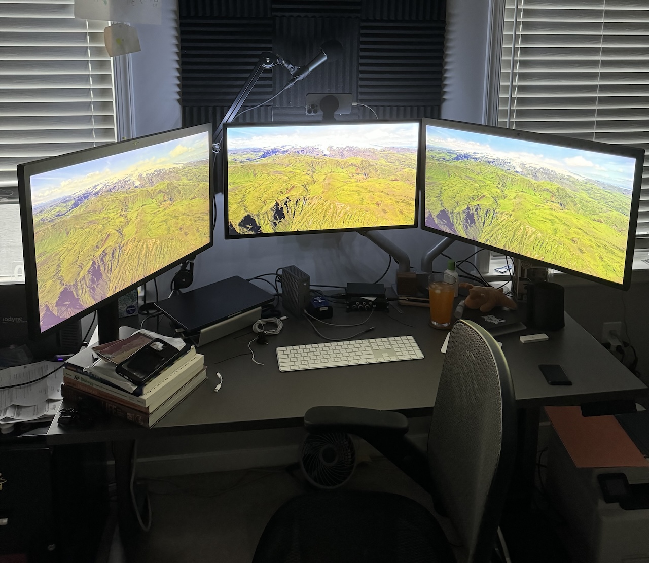 A messy desktop with 3× 5K monitors upon it.